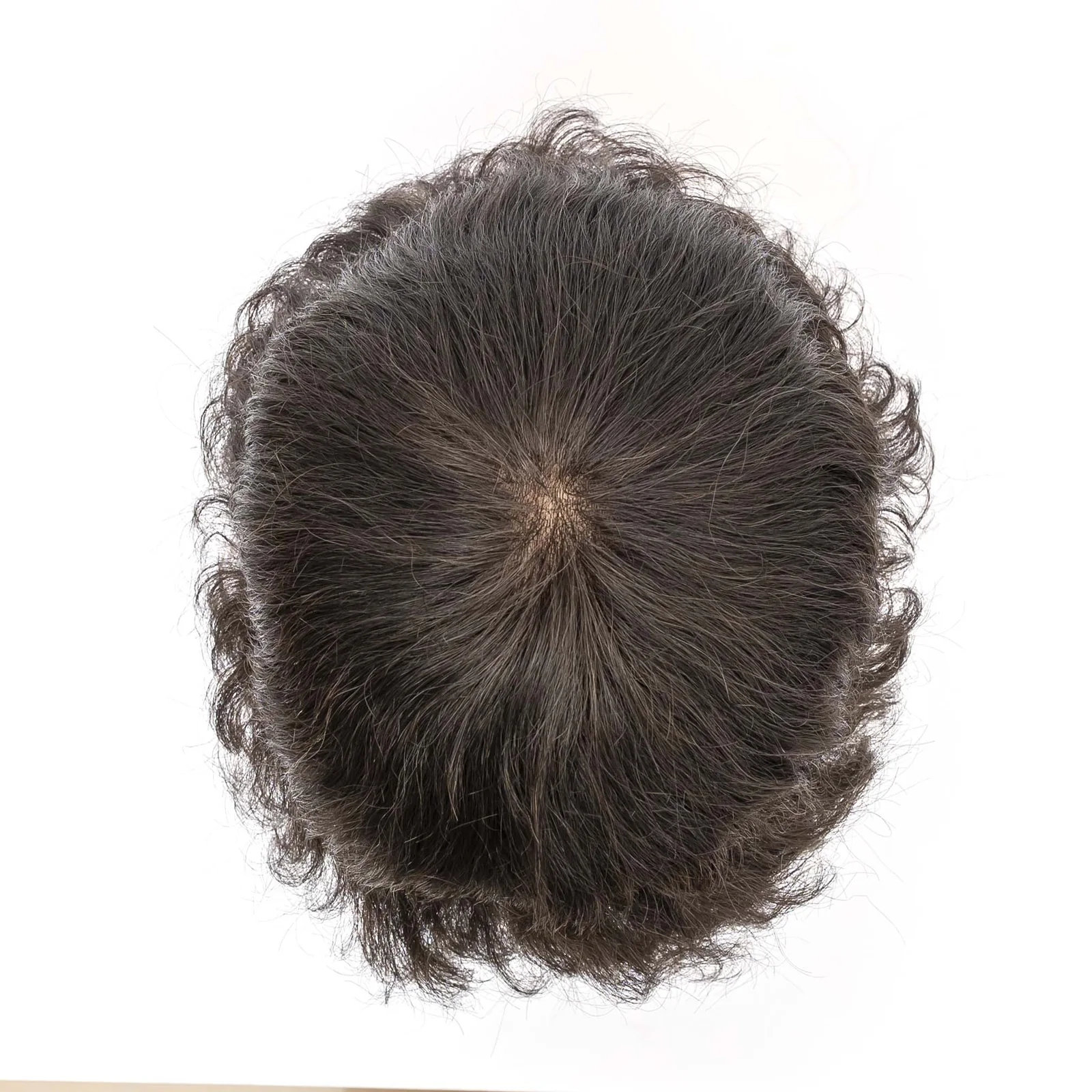 Top view of a dark hairpiece showing crown direction