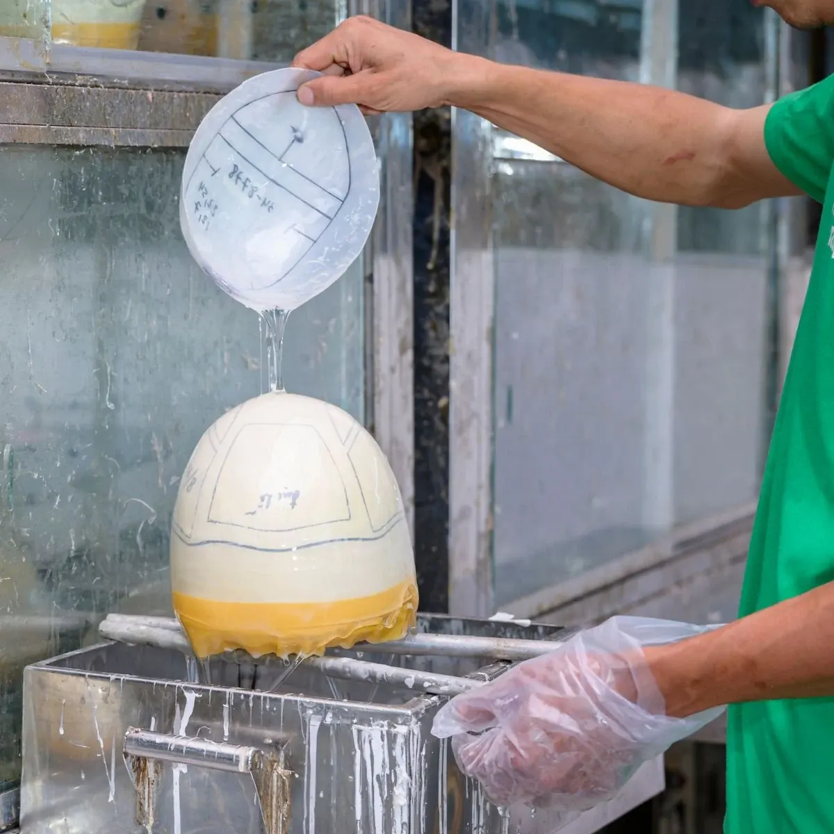 A technician working with a hair system base and mould