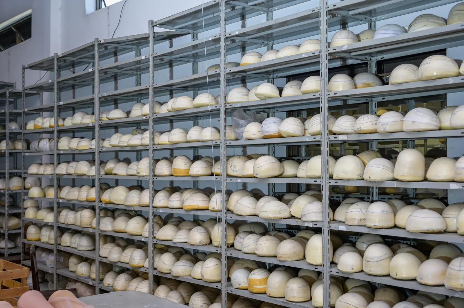Hairpiece forms organised on factory storage shelves