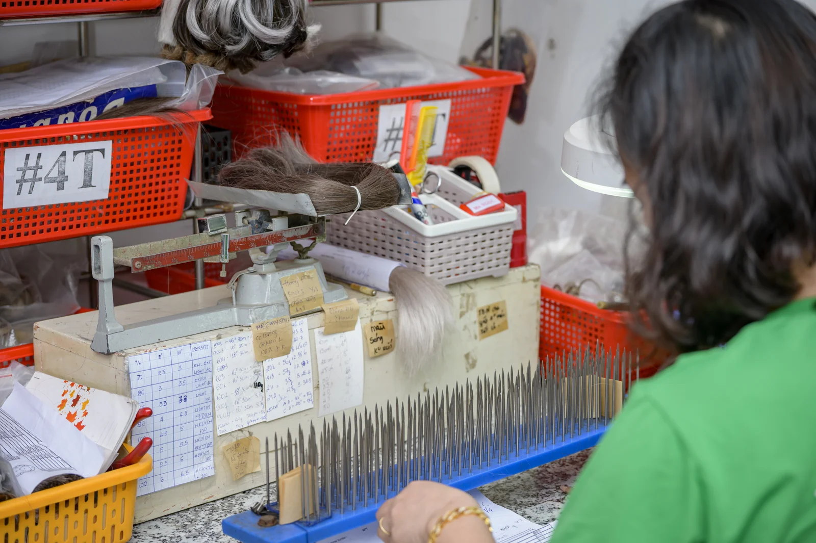 A Phuc Thien Toupee technician preparing hair at the workbench