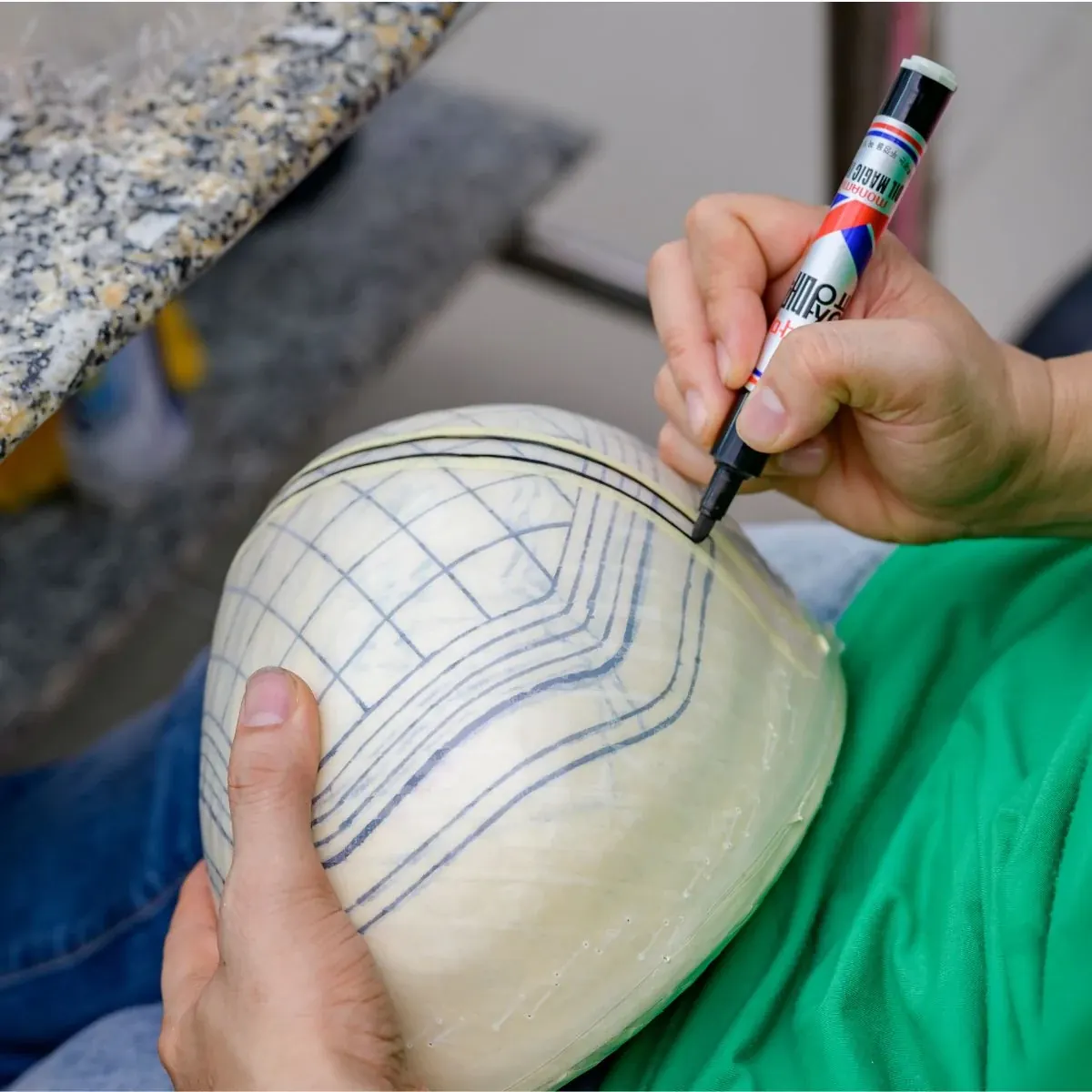 Technician marking a shaped hairpiece template